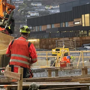 Bildet viser ein byggeplass med arbeidarar og maskiner