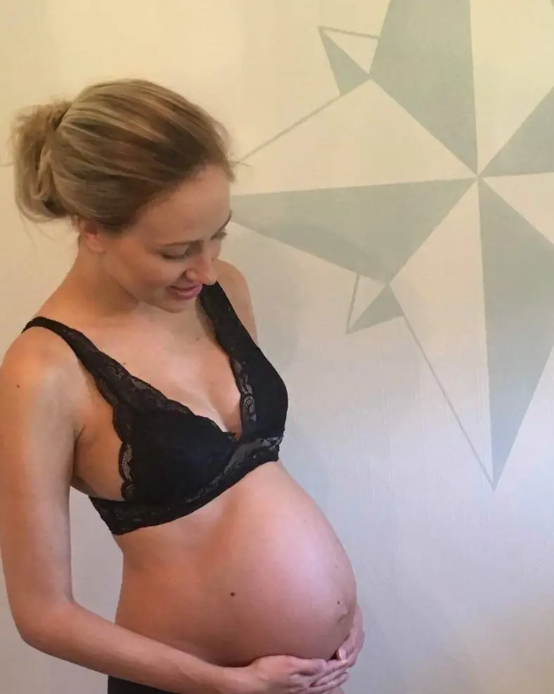Ei gravid kvinne som viser fram magen sin