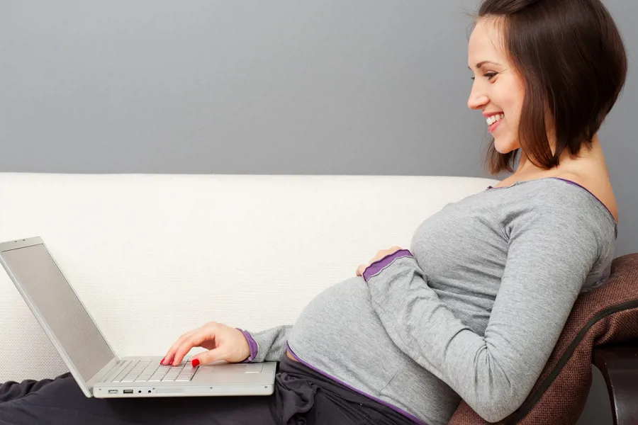 gravid kvinne med laptop